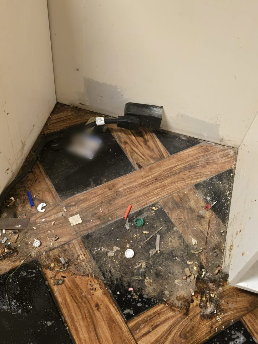 Utility corner with construction debris and standing water before Kidoti Clean rehab cleaning, Birmingham AL