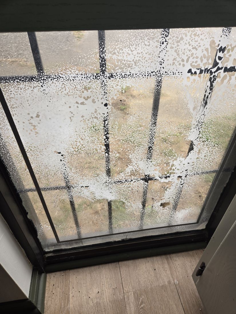 Salon window glass streaked with construction residue before Kidoti Clean post-construction cleaning, Birmingham AL
